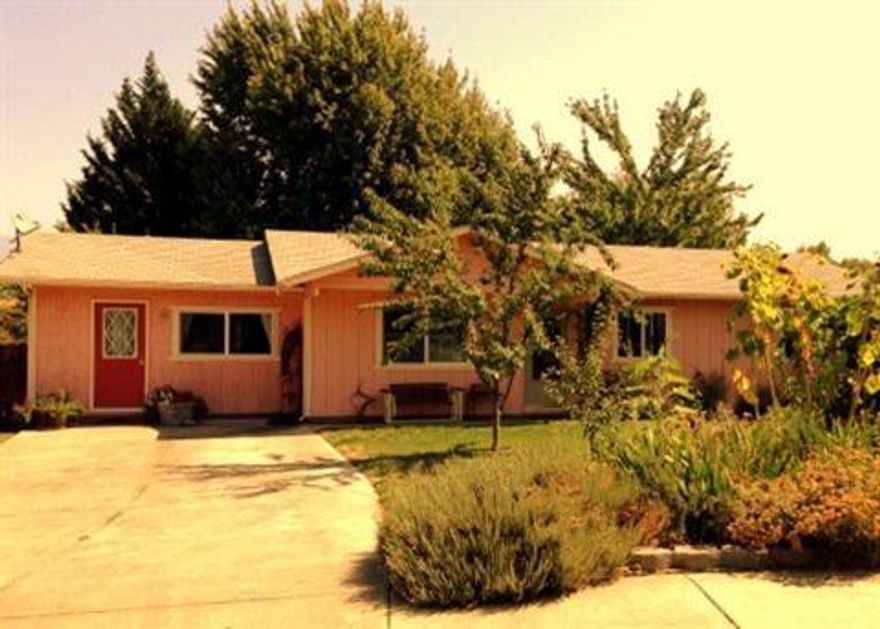 Gardener's Delight. Over quarter acre lot covered with flower and vegetable beds and lots of fruit and nut trees (almond, plum, peach, pear, hazelnut, cherry, apricot, apple) and other large mature trees in the private back yard. Stainless steel dishwasher and refrigerator included. Garage has been converted to a very nice office with separate entrance, but could also be a 4th bedroom (has a closet). Beautiful newer solid oak floors in LR, hall and one bedroom, and marmoleum in kitchen , bath, and half bath/laundry room. Built as super good cents in 1993. Very nice covered back patio. Storage shed. RV parking.