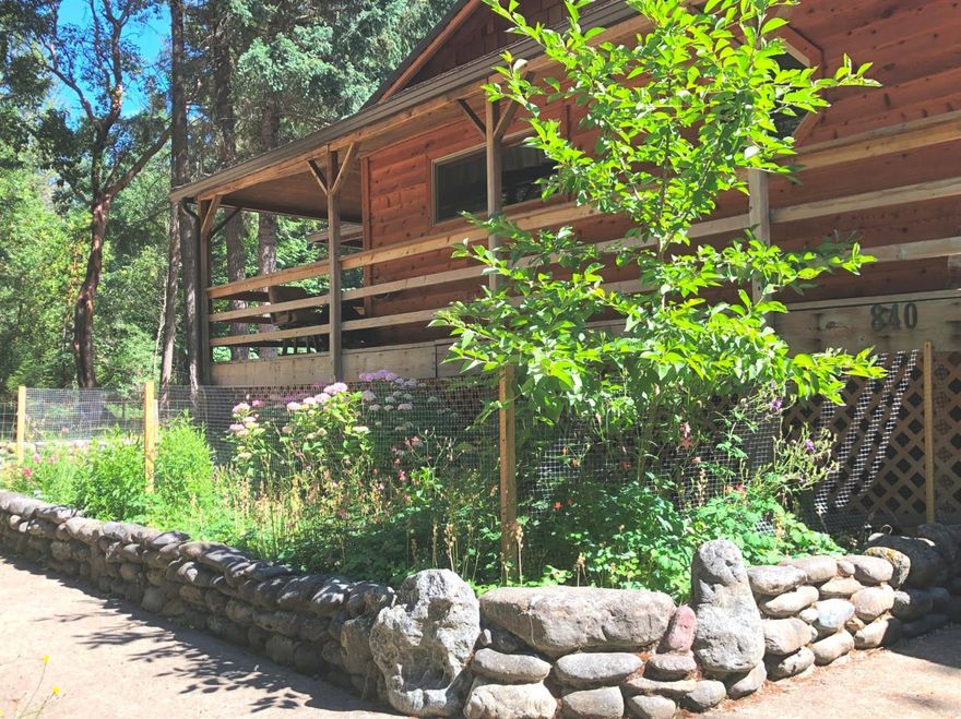 This is a beautiful multi-family dweling on 4+ acres of a park-like mostly-level lot. The one-story main home has 1,520 sq. ft. of living space, all with beautiful carpentry and exquisite design and finishes. The main house sits high above the ground, has cedar lap siding, 2 bedroom and 2 bath, a complete wrap around deck, and a 700 sq. ft. deck with a same-size shop under it. The inside of the main house is lit by large windows and many bright sky lights. There's solid bamboo flooring all through the house, knotty pine siding, and pole ceilings. Next to the main home is the guest house, built at the same high quality as the main house. It has 700 sq. ft. of living space with a kitchen, bathroom and bedroom. On the NW corner of the property there's an additional dwelling unit (cabin) with 630 sq. ft. of living space, including a kitchen, bedroom and bathroom. There's a year round creek at the SW side of the lot.There's a barn,with 2 wide roll-up doors,currently used as a 2-car garage