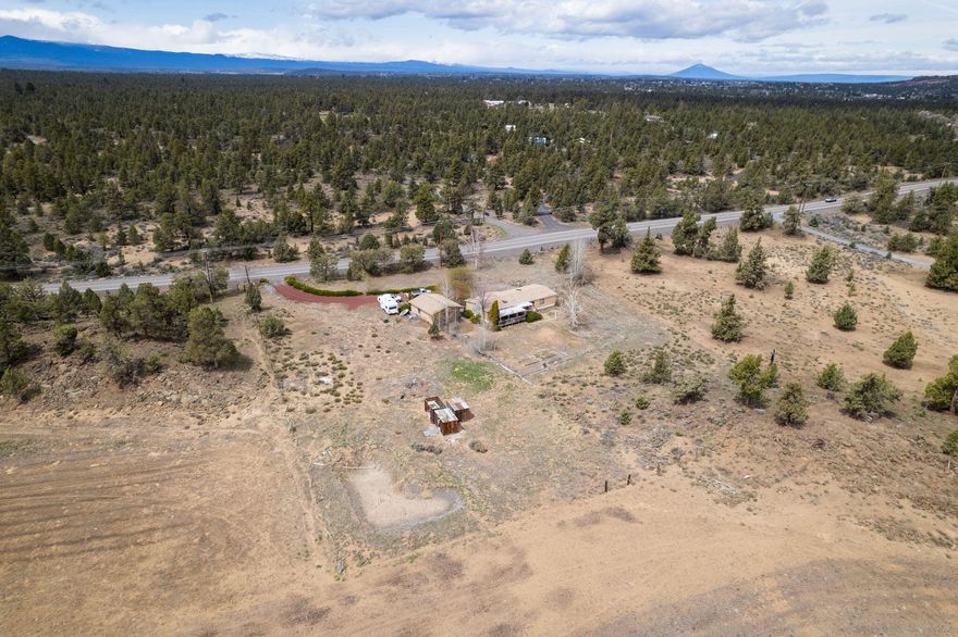 This small acreage property with 1.47 acres of irrigation has a very private  feel and is conveniently located between Bend and Redmond. Just a short drive to the highway entrance. The spacious 1980 manufactured home needs work, but offers a very functional layout. There is also a detached stick built, extra deep,  2 car garage with shop or storage space along the back wall. That space is partitioned off with a wall from the main part of the garage. There is a chain link fenced off area around the back of the manufactured home that covers a fairly large area as well as some old wire fencing around much of the perimeter of the property.  Come with your vision of what this property can be, and turn it into a reality.