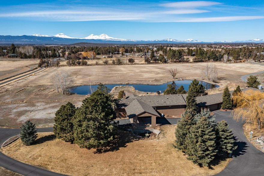 The Central Oregon lifestyle can be yours! Situated behind a private gated entrance on 21.66 acres with 17 irrigated acres and two ponds is a mostly single-level custom home with massive Cascade Mountain views. Walk through the front door to view floor-to-ceiling windows that showcase mountain and pond views. In addition, the home features vaulted ceilings, an open kitchen w/ built-in fridge and stainless appliances, hardwood floors, a fireplace, 8-ft doors, large bedrooms, a 6-car garage and a huge partially finished basement. Need a space for family or work?... Attached to the other side of the garage is a 1,421sf fully remodeled single-level additional dwelling, featuring a full kitchen, living room, 2 bedrooms & 2 baths. There are outbuildings for all your hobbies, including a 2,016sf ranch/shop building with a beautifully finished bonus room, a 2,304sf shop with an RV door, and a 1,800sf machine/other shop. Come and see how your acreage dreams can come true!