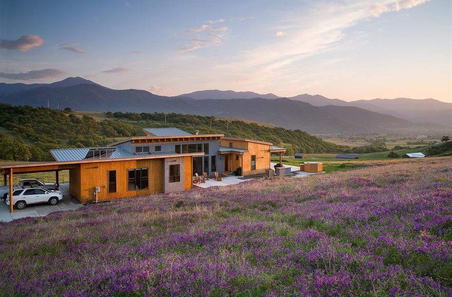 One-of-a-kind passive solar home by renowned architect Carlos Delgado, thoughtfully sited on 30 acres within a private valley just 5 miles of downtown Ashland. Designed for an integrated experience with the outdoors, home features walls of windows and sliding glass doors, airy vaulted knotty pine ceilings with exposed beams, designer lighting, slate floors, and radiant heat. Open concept kitchen equipped with bamboo floors, stainless 5-burner Wolf range, Sub-Zero refrigerator, Miele dishwasher, convection and steam ovens. Master suite has a large skylight, walk-in closet, and ensuite bath with dual vanity, slate floors and shower. Bedrooms outfitted with built-in shelving and wool carpeting. Grounds feature expansive poured concrete patios to take in 360-degree panoramic scenery and magnificent sunset views, an outdoor kitchen area, mature gardens, five acres of TID irrigation rights, and creek frontage.