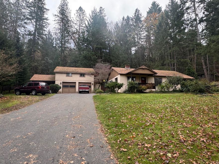 Wonderful 3 bedroom, 2 bath 1,502 SF home in Park Like setting across from the Rogue River. BRAND NEW SEPTIC INSTALLED. Property Includes 130 LF Direct River Access & small beach just across the road. Effective Remodel in 1970 added 3rd room & 2nd bathroom + patio access. Home boasts original tile & wood craftsmanship, brick fireplace, gorgeous Parquet Floors, solid wood cabinets & Oversized Canning/Laundry room. The 2-car garage has electrical in 110 & 220amps for many hobby configurations. Bonus room above has retractable stair access is set up as activity room & could be additional storage or Detached Living Space. Central HVAC installation with new ducting, works for recirculation of fireplace heat just needs heat pump. Home is conveniently located between Grants Pass & Rogue River. Expansive front yard with Mature Trees & a gentle slope create a serene feeling. Home is a touch dated yet Solid Condition Don't miss seeing this quiet beauty for your self