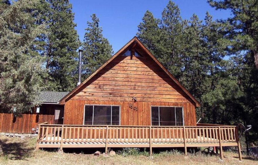 Enjoy the best of both worlds: a nature retreat, nestled in the pines, but with great sun exposure on the wrap around deck and in the back yard. Living room boasts cathedral ceilings, open beams & a wood burning stove. Spacious open concept kitchen has a large breakfast bar. The 1.4 acres parcel has a fenced yard is a great place for your critters to play and an good sized storage shed. In addition to the 2 car garage, the oversized driveway and flat yard provides room for vehicles and toys. Bedrooms are on both floors and allows for privacy between household members. The upstairs loft provides a great