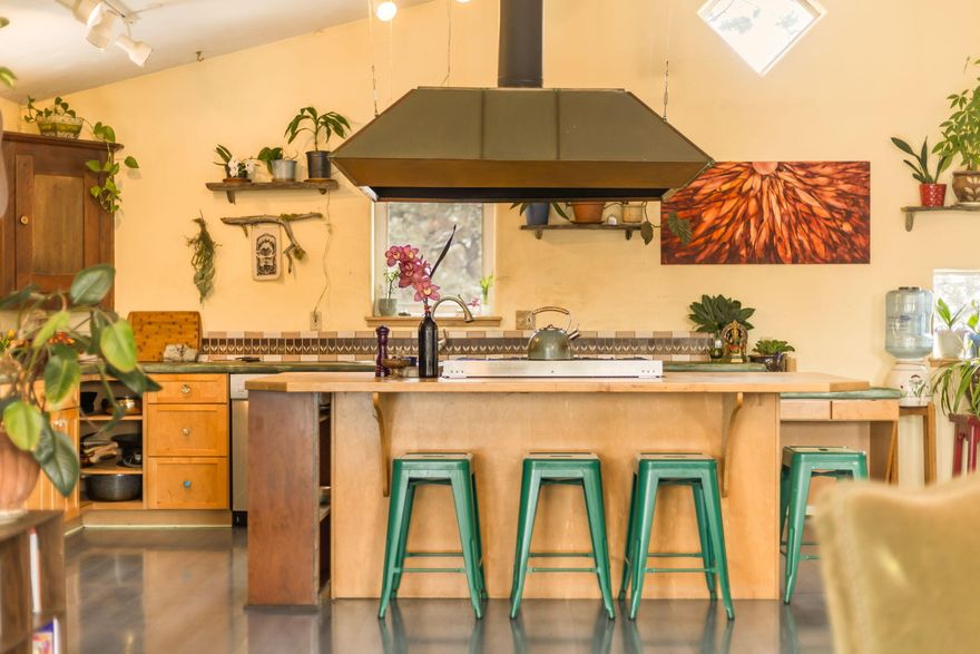 This strawbale home has been a healing sanctuary for each of its stewards. She is soft in colors, whimsical in design, of the earth in her creation, and both playful and nourishing in spirit. She is warm and light by day, while snug and dreamy in nighttime. She is part of a co-housing community, but how and when you engage is yours to honor. She has a garage, but asks that you walk a path through nature before returning to home. She has a sunroom which hugs the soul, diamond windows in the family room which frame the cycling moon, and panoramic windows which face the mountains and envelop you in the evening's sunset. Her blue, radiant heated floors have enjoyed much dancing throughout the decades, and her storybook kitchen inspires the ongoing serving up of a lot of yummy love. And, thankfully, she dwells right next to the homestead root cellar which was recreated into a sauna, so you get to steep in the goodness of life when it's time for body and being to rest and renew.