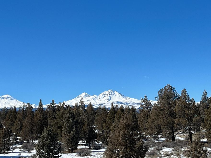 This High Desert residence cohesively blends the interior space with the exterior and offers stunning views through the large glass walls of windows to the ''10 Peaks'' of the Cascade Mountain range. The desert beauty is viewed from a remarkable spatial context in the home's uniqueness and comfortable living style. This quality home offers a reverse living floor plan to capture these views from the Great room, dining, kitchen. This level also includes a spacious Primary en suite, wood paneled office, second bedroom and full bath. Downstairs features another large bedroom, a second media /bonus /office space and full bath. Large closets and multiple storage spaces. Attached triple car garage with built-in storage shelves and mechanic well. Cottage with bedroom, full bath, and kitchen area. Large shop, all on almost 10 acres in the coveted Tumalo area. Horses, llamas, alpacas and chickens allowed. Coral in place. Gated entrance at the end of a private lane. Call for your showing today