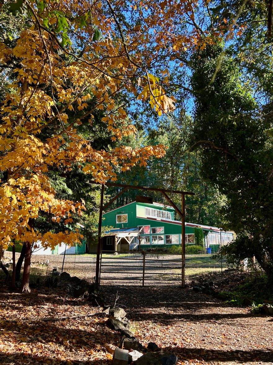 Private Forest Retreat for Nature Lovers & Homesteaders. Tucked away on 20 peaceful acres of towering evergreens, moss-covered outcroppings, and sunlit meadows, this property offers privacy, beauty, and sustainability. Enjoy starry nights from the dock on your own 1-acre spring-fed pond or watch wildlife roam the landscape. The home is filled with light from vaulted ceilings and natural wood accents. The main level features
a cozy woodstove in the living room, while the upstairs loft/family room includes built-in bookshelves. There are 2 bedrooms, 2 bathrooms, and 2 versatile bonus rooms ideal for guests, hobbies, or a home office. Off the living room, a 928 sq ft solarium offers year-round growing with a waterfall and planting beds. There is also a 28x96 greenhouse with lighting and irrigation. Gated, with deer fencing, gardens and fruit trees. Peaceful, private, and ready for your homestead vision.