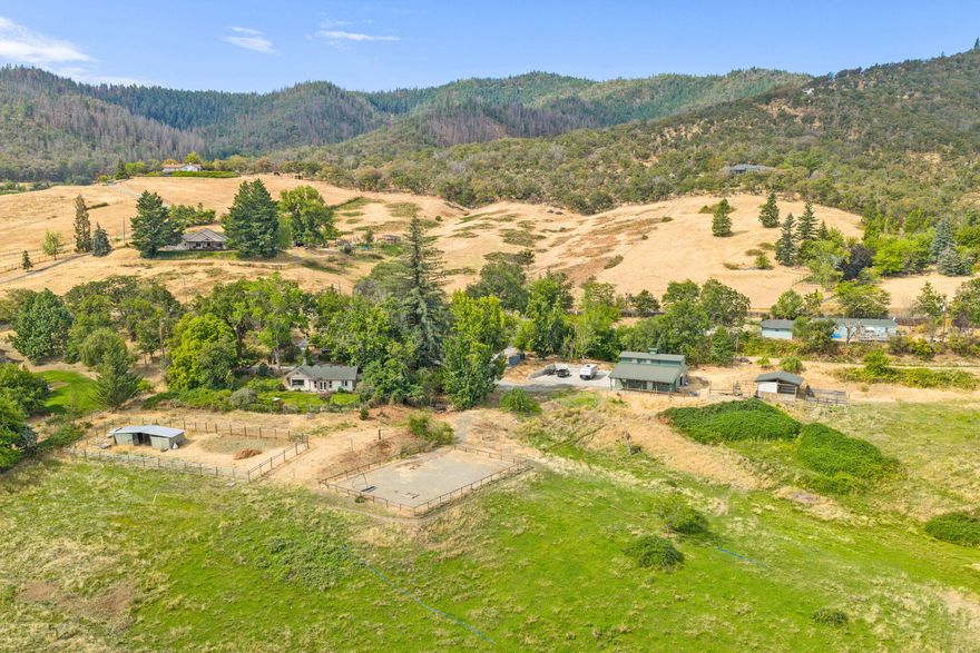 Breathtaking multifamily equestrian property with panoramic views, just minutes to Jacksonville, Ashland & Medford! Situated on 7.9 acres, this rare gem features two homes, irrigated pastures, and full fencing—perfect for horses, animals, gardens, or entertaining. The spacious 1 bed/1 bath main home offers privacy, natural light, and serene views. The 3 bed/2 bath ADU with 2-car garage has been beautifully updated with new flooring, kitchen, baths, appliances, and tiled shower. Horse amenities include a 1,680 sq. ft. barn with tack room, hay storage, 4 stalls, and an adjacent arena, plus a new 2,700 sq. ft. concrete pad and a 300 sq. ft. upstairs studio/rec room. Ideal for multigenerational living, equestrian use, or simply enjoying Southern Oregon's beauty. Plus, property includes an assumable $400K loan at 3.875%—a rare opportunity to lock in a low rate! Information per Seller. Buyer to do own due diligence.