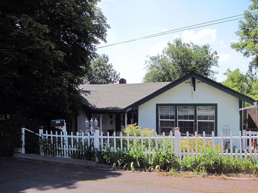 Enjoy the beauty of an Artists home. This lovely home is full of color and original hardwood floors with handmade tiles on the fireplace and in the bathroom. Each room has been lovingly restored to bring out the romance of the times. The home has many updates: newer roof, windows, interior and exterior paint, electrical and sewer updates, extra insulation in ceiling and new gas furnace. The beautiful gardens are a true showcase, and all done organically. All cement fountains, planters and benches plus all outside wall art and a hot tub come with the property, which includes a partial additional lot. Also in the basement is a great heated shop space and additional garage. Above the garage is a shed and greenhouse for more storage and for starting those early plants.