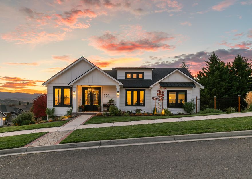 Perched above the valley in desirable East Medford, this stunning home showcases modern design, tasteful finishes & sweeping views. The open-concept layout features tall ceilings & expansive windows, creating a bright & welcoming atmosphere. The spacious great room connects to the kitchen & dining area, highlighted by quartz countertops, a butler's pantry & access to a large composite deck for enjoying the views. The primary suite is conveniently located on the main level, with a spa-like bathroom featuring a tiled shower, large soaking tub & walk-in closet. A 2nd bedroom & dedicated office space are also conveniently located on the main level. Downstairs, 2 additional bedrooms and a second living area with a built-in wet bar offer flexibility for everyone. Thoughtful touches continue with solar panels, an EV charger in the oversized two-car garage & well-established landscaping. Modern sophistication meets timeless charm — the perfect blend of comfort, design, & breathtaking views.