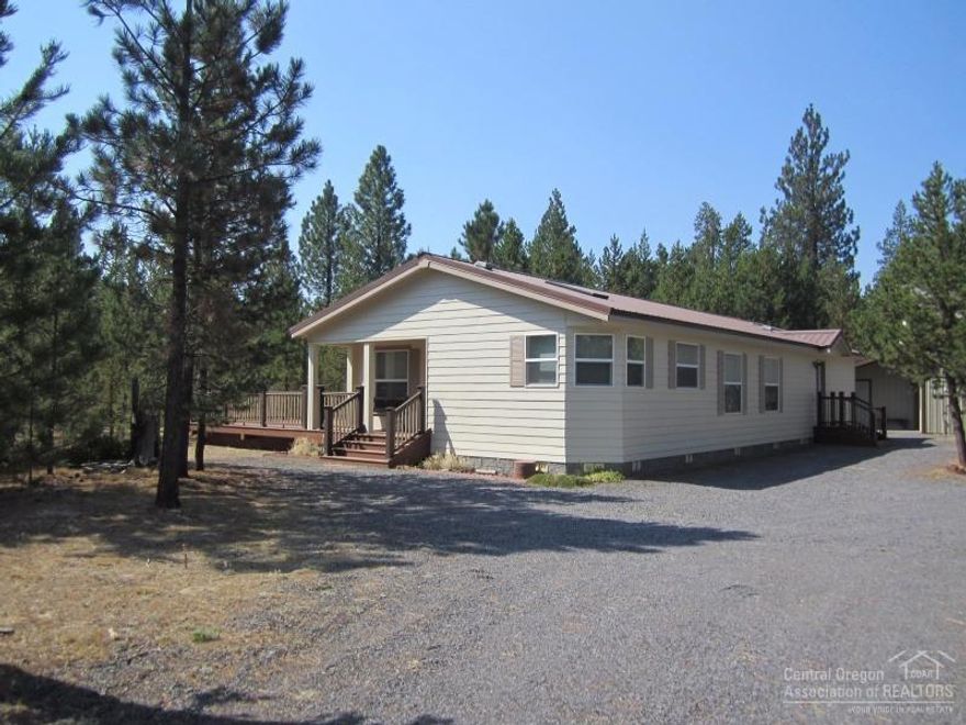 Great opportunity to own this beautifully maintained home. 3 bed 2 bath, great room style living. electric forced air heat, large laundry room, very private lot, backs to BLM, paved road, corner lot, expansive decking with great forest views and retractable cover. 1596 sq ft shop with RV doors and a 9x26 enclosed work area with bay door. Circular drive for great acess. Lot next door 15581 Federal Rd may be purchased as well.