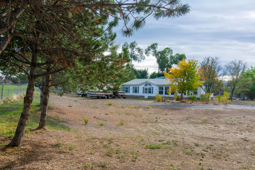 Light and bright 3 bd 2 ba 2004 sq mfg on 1.95 acres. Granite counters, new cabinets, tile floors, new bathroom vanities, tiled walk-in shower in primary bath. Appliances 5 years new. Certified pellet stove. Heat pump and air cond. Open floor plan. Sun room and 35x16 enclosed porch with heating. The 32x60 DREAM SHOP is a must see! 5'' thick concrete floors, two 14' electric doors, pull through shop, all plugs 220. HEATED FLOORS! 200 amps, solar ready, 31x27 loft. Full bathroom and laundry area, utility sink and plumbed for another sink. Property has 2 septic tanks, 2 wells (one for irrigation and one domestic) Three RV spots 50 amps each. RV Clean out. 16x20 storage shed. 24x22 bldg with loft, electric and water plumbed to it. Detached 2 car garage with two storage areas. Underground sprinklers. Security Cameras. Electric gate. Fenced. So many possibilities.  Call today and schedule a showing.