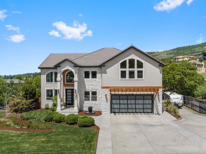 Absolutely stunning contemporary East Medford hills home in the desirable Saddle Ridge Subdivision. This exquisite home has views of Roxy Ann & city lights perfectly situated on .34 ac. Fabulous architectural details w/custom millwork, soaring 22' ceilings, incredible natural light, hardwood, wool blend carpet, lg Heat n Glow fireplace w/custom bullnosed marble hearth & walls. Wonderful 3,922 sqft floor plan w/4 bedrooms, 3.5 baths, bonus room, formal & informal areas. True gourmet kitchen w/granite counters, custom cabinets & newer commercial Thermador stainless appliances w/double WiFi oven. Spacious mstr suite has sitting area w/gas fireplace & private deck to enjoy sunset & mtn views, luxurious mstr bath w/huge walk-in. Additional bedrooms w/vaulted ceilings & walk-in closets(one has attached bath). The heated saltwater lagoon pool, outside kitchen, fire pit & ample parking make entertaining a breeze. 4 car garage w/Tesla wall charger + 65' RV pkg. This home is absolute perfection!