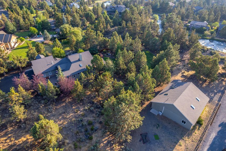 Experience luxury and tranquility on a private 2.5 acres with a shop in the heart of Bend. This beautiful 2,977 sq. ft. main level living home offers 4 bedrooms and 2.5 baths set against the serene backdrop of the Pilot Butte Canal. An open flow great room is perfect for entertaining. The chef's kitchen has a breakfast bar, stainless steel appliances, granite counters, induction cooktop, and double ovens. The spacious primary suite has a spa like bath and private outdoor access. A flexible 4th bedroom/bonus area upstairs provides fantastic separation of space. Outside discover a paver patio, greenhouse and gardens, and a fully fenced backyard.  Endless possibilities with the detached 2,208 sq. ft. shop with 1/2 bath, new roof and HVAC. Oversized 3-car garage with 2 EV chargers and storage for all your gear. Property has 1.25 acres of COI rights. Proximity to walking trails, Pine Nursery Park, schools, and restaurants make this home the perfect blend of country living and convenience.