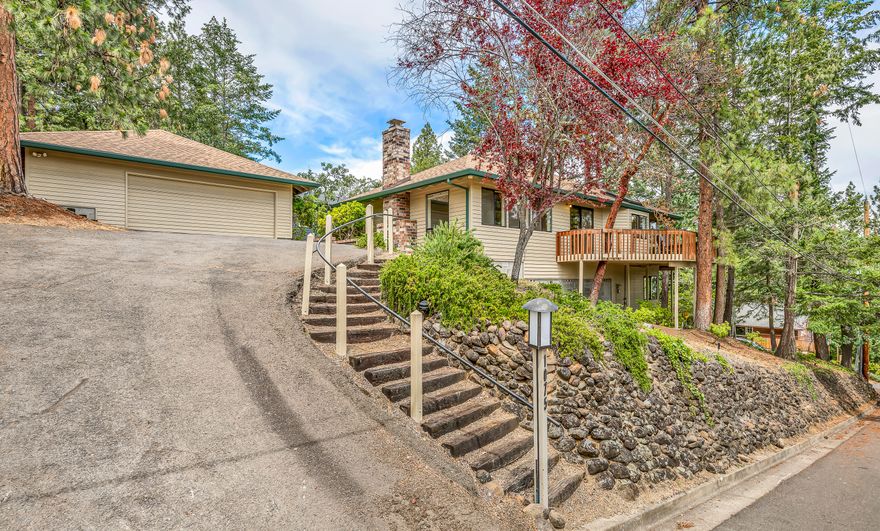 Spacious view home sited on a corner lot above the boulevard and SOU with nearby hiking and mountain biking access via Ashland's White Rabbit Trailhead! Main level features unique architectural vaults and multiple skylights, a huge wrap-around cedar deck, living and family rooms with brick fireplaces, kitchen with honed granite counters and island with natural gas cooktop, formal and informal dining areas, primary bedroom with walk-in closet and full ensuite bath with soaking tub and new shower, guest bedroom or office, half bathroom, laundry room, and slate entry. Lower level has two additional bedrooms with double closets, full guest bathroom with oversized shower, and a sitting area with sliding glass door to poured concrete patio. Detached oversized two-car garage with pull-down latter for attic storage. Deer-fenced garden with raised beds, and natural landscaping with well-maintained mature evergreens. Inquire with agents for details and access to additional documentation!