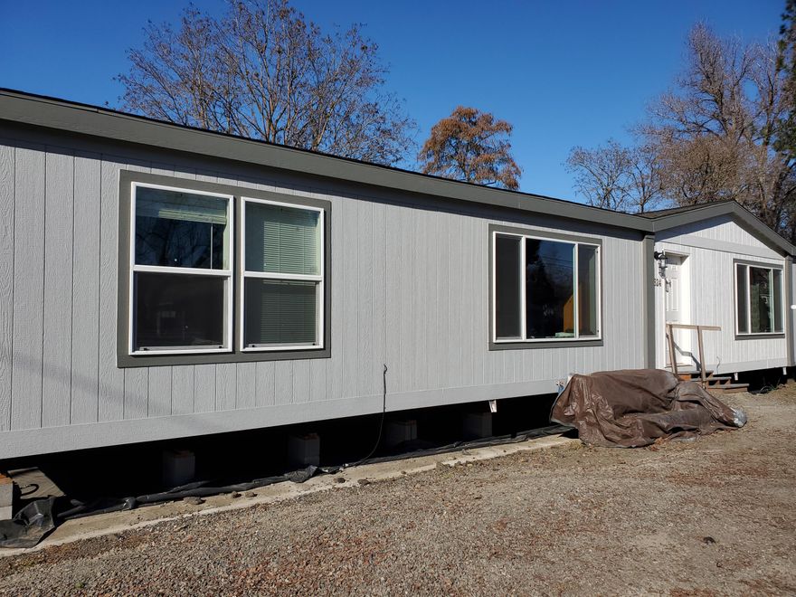 This new manufactured home is right on the creek.  Home is a beautiful 4 bedroom 2 bath home with a beautiful kitchen with island.  A cozy wood stove adds to the ambiance of the dining area. The bedrooms are on a split floor plan adding to privacy. Seller is willing to sell the manufactured home separately.  Home currently does not have water.  Buyer to do their own due diligence. Home is being sold AS-IS.