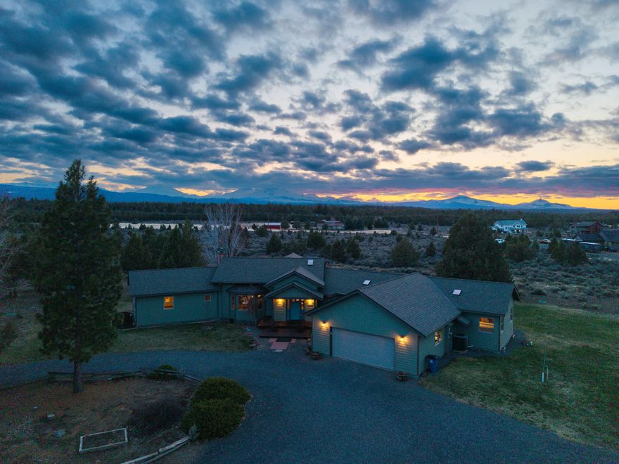 Custom single level home w/panoramic Cascade Mountain Views, guest house/shop & 1536sf insulated/heated shop. Upon entering the great room, you're greeted by unobstructed views & newly finished hardwood floors. The kitchen has concrete counters, Wolf cooktop w/hood, single bay sink, oven & convection oven, expansive storage & pantry. The great room has dining, a nook, living room w/wood stove & a slider to the back deck. The primary suite has private access to the hot tub, custom concrete single pour vanity, double headed tiled shower & radiant floor heat. Both guest bedrooms on the opposite side of the house have access to the deck & share a bath w/tiled shower & soaker tub. The guest house has a kitchen/bath & is attached to a garage/shop. Another insulated/heated workshop has 220 power & wiring routed for large equipment. A fenced garden area w/drip system also has a green house w/raised beds. Public land is a short walk from the home & is great for horseback/mountain bike riding!