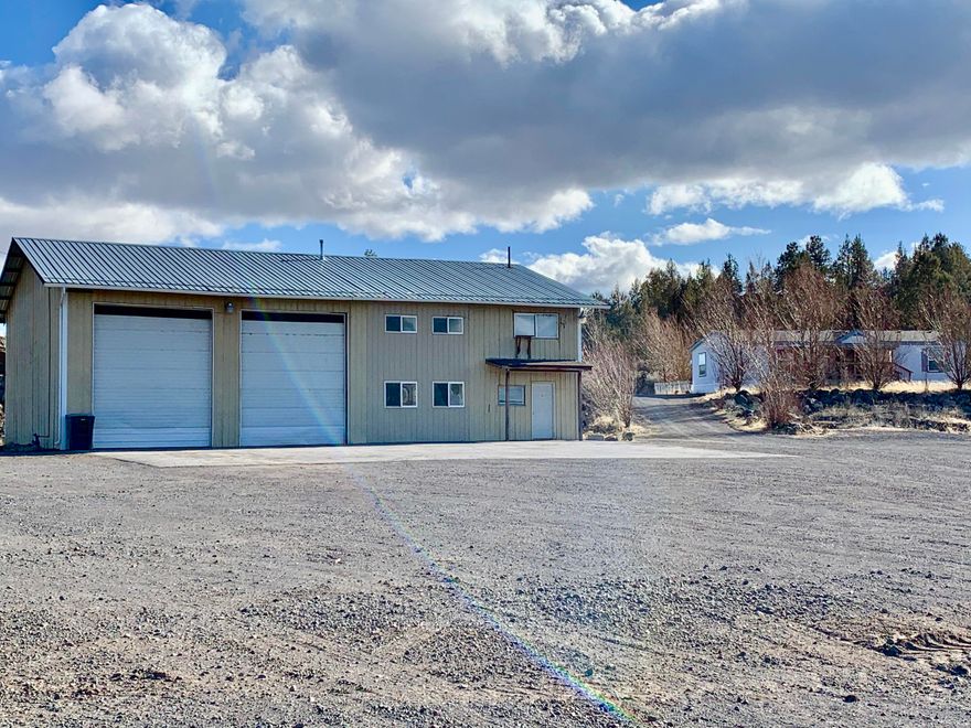 Sale includes an Industrial Shop and a 1998 manufactured home on 6.73 acres with Highway 97 frontage. Room for large trucks. Shop is approximately 2400 sq. ft. with private offices upstairs, break room, gated tool storage room with sink, & two bathrooms, 1 with a shower. Two-bay heated truck shop with approx. 14' roll-up doors and 220v.  Property has a well and septic. Storage shed along the back side.  Manufactured home is a 1998 double wide and currently occupied. Three tax lots and zoned Light Industrial. Rent both out or live in the home and run your business out of the shop.