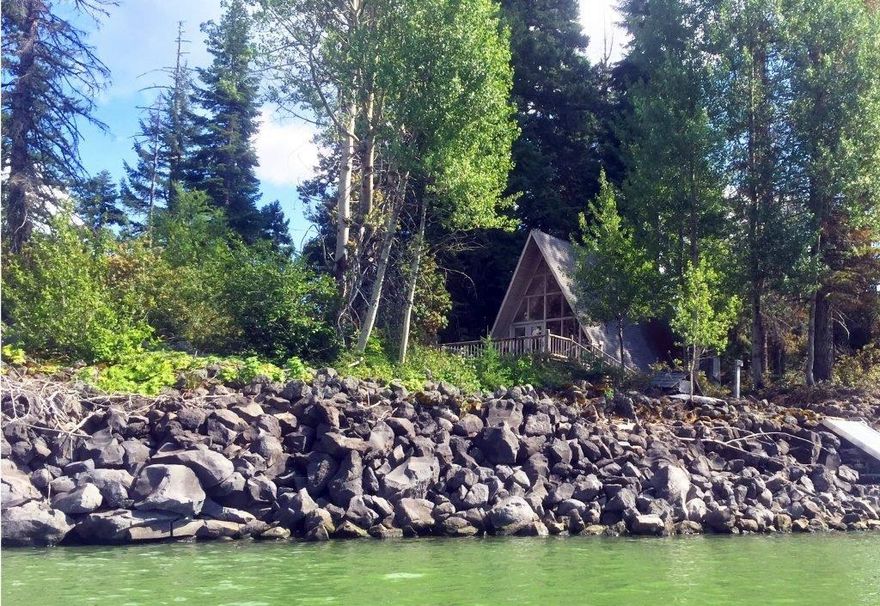Wonderful A-frame cabin on the south side of Fish Lake w/soaring ceilings & a north facing wall of windows beautifully framing Mount McLoughlin. Although Mount McLoughlin is breathtaking, this particular cabin is even located on a private point with over 180 degree views of the lake & includes a private boat dock (aluminum boat included)! This cabin is unique w/no direct neighbors. The cabin itself is bright w/natural light, open & attractive, w/a loft bedroom upstairs & a private bedroom downstairs. The floorplan feels particularly spacious as it opens to a large deck that offers ample room for entertaining. The cabin is served by a wood burning stove, an outdoor shower, water to the kitchen & the private bedroom vanity, & an outhouse. About 8 miles from Lake of the Woods & 45 minute drive from Medford & quick boat ride. This does not include Real Estate, the property is on a land lease w/the Forest Service $2211 annually. Taxes were only $639 in 2017. Cash only. Appointment Req