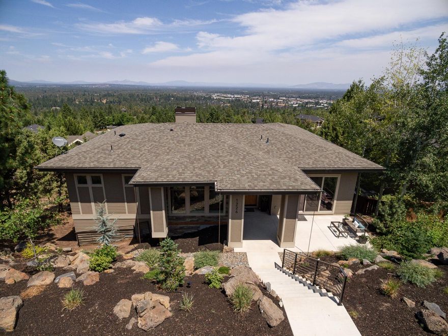 This contemporary home with mountain views is located in Bend's highly desirable West side. The dream kitchen features an oversized quartz island, stainless side-by-side fridge & freezer, built-in Dacor espresso machine, 6-burner gas range and the open floor plan to interact with everyone from this gourmet hub. The star of the dining area is the custom built-in climate controlled wine cabinet. From the main level primary suite, relax in the luxury bath or walk out to the deck for views of Mt. Jefferson, Mt. Hood, Smith Rock and the Ochoco Mountains. 3 additional bedrooms are on the lower level (one is currently used as an office) along
with a fun bonus room. The heated driveway will get you through winter!