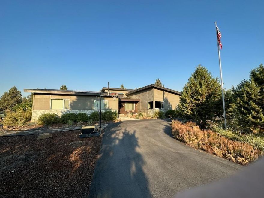 Contemporary Single Level Ranch style home sitting on 3.26 acres in SE Bend. Just minutes to downtown, shopping, and all amenities. 4 Bedrooms, Designated office, Bonus Room, 2 full bathrooms, great room concept. Custom Built in 2015. Large green house, garden, chicken coop, hot tub, shed/outbuilding. Primary bathrooms floors are heated for comfort in winter. Beautiful stack stone fireplace. Simply Safe Security system, Under counter lighting, Wired for surround sound, wine refrigerator.