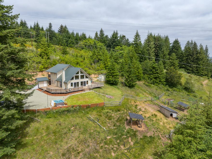 Welcome to Bill Creek Ranch—56.31 acres of privacy, views, and modern comfort just 10 minutes from Bandon and the Oregon Coast. The land stretches from level pasture and Bill Creek to a ridgetop homesite with panoramic valley and mountain views. The 2019 custom home sits above it all, featuring vaulted ceilings, wraparound deck, chalet-style windows, and an open layout with wood fireplace and gourmet kitchen. The main level includes a primary suite with remodeled bath, guest bath, and laundry. Upstairs are two more bedrooms, a full bath, and an open loft—perfect for guests or a home office. Covered decks off each bedroom offer a peaceful retreat. Upgrades include natural wood finishes, surround sound, and new flooring. With room for animals, gardens, or simple relaxation, this is a rare blend of coastal lifestyle, rural charm, and easy access to Bandon's dining, shopping, and the world-renowned Bandon Dunes Golf Resort.