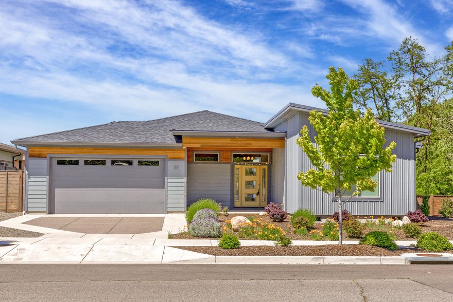 Gorgeous single level home in the sought-after Verde Village subdivision in beautiful Ashland Oregon. Earth Advantage Platinum certified for energy efficiencies and a healthy home. Open floorplan, spacious living room w/ cozy gas fireplace, built-ins and lots of windows to take in the views and allow for natural light to pour in. Kitchen has a quartz countertops throughout, huge center island, Kitchen Aid stainless steel appliance package and lots of storage. Three bedrooms, two and a half bathrooms with approx. 2042 SF.  Desirable layout has separation of the bedrooms, large primary bedroom suite with spa like bathroom, dual vanities, and walk-in closet on one end, two additional bedrooms and shared bath at the other. Stunning engineered Hickory hardwood floors throughout!  Two car attached garage w/ dedicated 220 V car charging station. Fully landscaped front and fenced in backyard, multiple outdoor patios and the lot abuts the greenway path and provides a wonderful setting to enjoy.