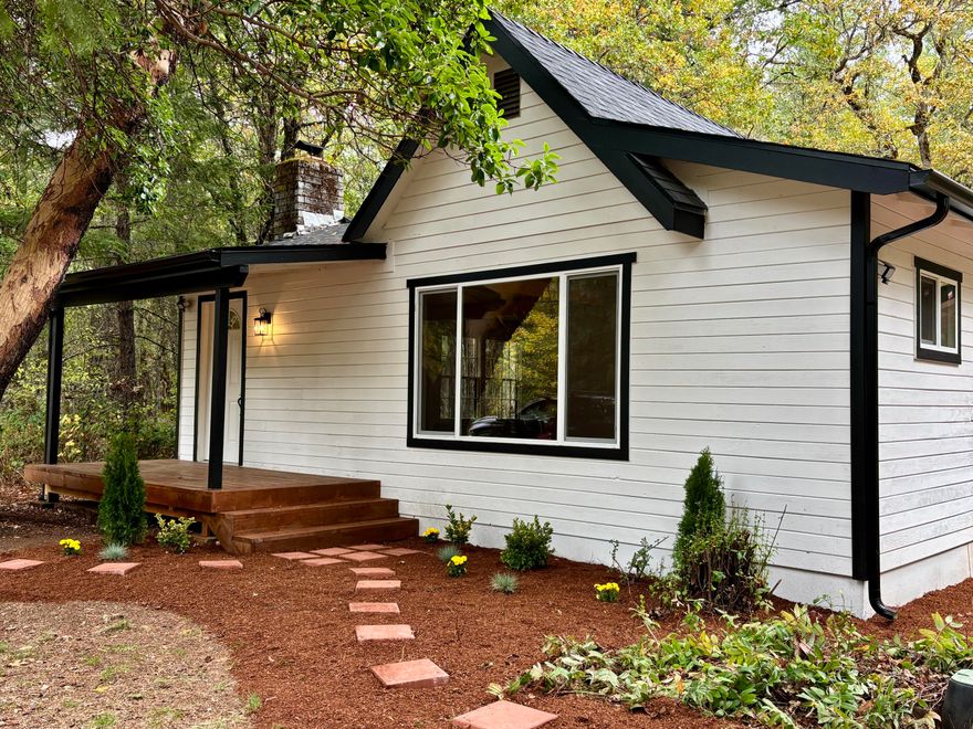 Peaceful 3 bed, 2 bath home on 2.38 level, wooded acres backing to BLM land. Versatile floor plan with potential ADU conversion—3rd bedroom/bath has private exterior access + plumbing ready for kitchenette and shared laundry access. Ideal for multigenerational living, guest accommodations, or rental income opportunities. Fully remodeled with luxury vinyl plank flooring, butcher block countertops and stainless appliances. New roof, vinyl windows and high-efficiency mini-split heat/AC (installed in both the main home and the potential ADU space). Special features include large rock fireplace and huge walk-in pantry/storage area. Bathroom features double vanity. Enjoy tranquil outdoor living with covered porches and fire pit. Property includes two driveway entrances, RV hookups, and a workshop/storage building for equipment, hobbies, or storage needs. All located within an easy commute to Grants Pass while offering the rural lifestyle of the beautiful Illinois Valley.