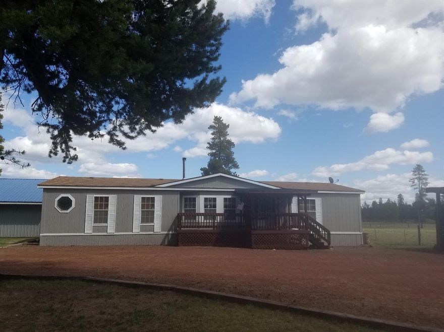 Park like setting with meadow and mountain views! 1991 very nice manufactured home. 3 bedroom 2 bath, fresh exterior paint, newer windows, certified woodstove. Open floor plan with 2 living areas. Kitchen is a delight with a work island. Large master bedroom and bath ! Super nice 30x30 detached garage/ shop. 2 car carport and woodshed. Yard is amazing with pond feature, covered deck for endless outdoor entertaining. Watch the wildlife out your back door!