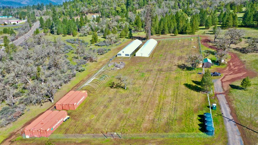 MULTIPLE OWNER FINANCING OPTIONS AVAILABLE WITH ONLY $75K DOWN! Nestled in Southern Oregon's stunning Illinois Valley, this 25.44 ac farm is a prime location beside BLM acreage, offering unparalleled access. This previously licensed OLCC farm with 200' x 455' premises is turnkey. With multiple wells, including a new addition pending approval, & a groundwater use permit, water access is secure. The property features a Forest Dwelling Permit & 400 amp power. Six 40' HC Containers, two automated Light Dep greenhouses, equipped with heating & lighting for year-round cultivation. Security is paramount with 44 HD cameras, motion sensors, & alarms. A robust power setup includes a lithium iron phosphate battery bank & solar charging. Fully irrigated fields, supplemented with quality soil & amendments, ensure optimal growing conditions. Four NSF water storage tanks & gas-powered pumps support irrigation. The premises are fully fenced with custom gates & offer room for expansion.