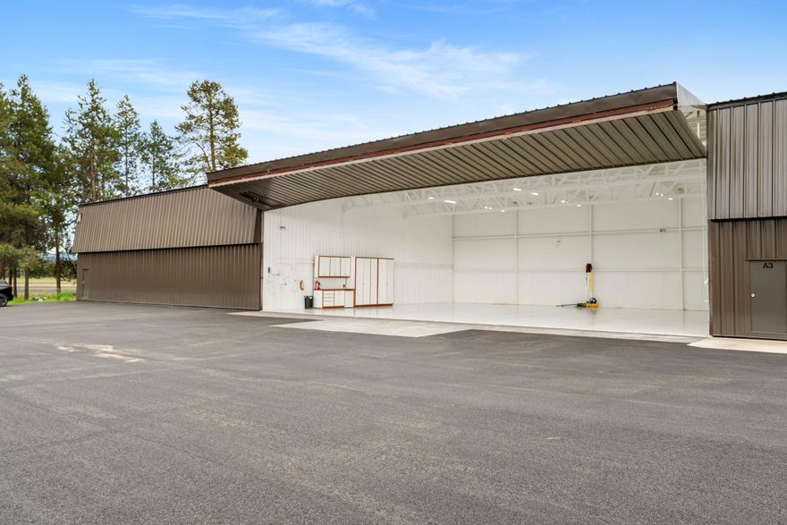 Presenting a remarkable opportunity for aviation enthusiasts: a 3,060 square foot executive hangar in Sunriver, which is a highly coveted and rarely available on the market. This structure features a spacious 50-foot by 60-foot hangar equipped with a 16-foot overhead door (tail clearance 15.5 feet), facilitating easy access for your aircraft. The floor has recently been enhanced with a durable epoxy coating, and exterior heat mats have been installed under tarmac to ensure convenient winter travel. Additionally, the hangar includes cabinets, a tug, an air compressor, and a mini fridge, making this hangar a ready-to-use haven for pilots. Do not miss the chance to own this unique property.