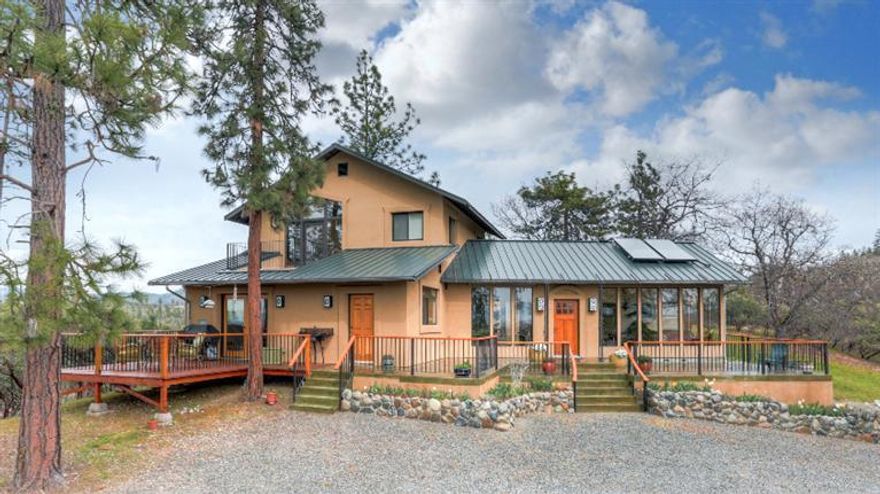 Custom artisan built home on a ridge w/5.66-acres. The high quality construction of this energy efficient home features 8'' walls, solar hot water & hydronic heating. The many windows in every room have gorgeous views & bring in abundant natural light. The interior features beautiful Tuscan plaster throughout, handmade tiles & maple cabinets in kitchen & bathrooms; stained concrete floors downstairs & Brazilian cherry upstairs. The main floor includes a large solarium w/tiled fountain. There are patios & decks on 3-sides of the house for enjoying the scenery & wildlife. Detached tiled sauna house w/sink, toilet & shower, fully insulated & drywalled 28x40 shop w/30' chain hoist, 12x30 heated studio apartment, circular stone raised bed organic garden, fruit trees & detached 24x24 garage. It is the perfect setting for the lifestyle you have always dreamed of. Backed by BLM land in beautiful surroundings this home is close to all the Rogue has to offer, yet completely private.