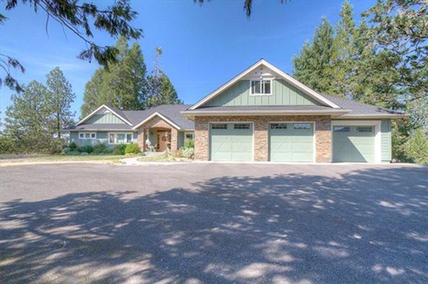 Gorgeous custom home in South GP, situated atop 2.40 acre knoll with a beautiful vista of the city and hills to the north and west. Paved drive leads to quiet privacy in the shade of mature evergreens and low maintenance landscaping. Formal entry with sitting area ushers you into the great room with vaulted beamed ceilings, the formal dining area is expandable for large gatherings, and the kitchen is the jewel in this crown-- with granite counters, a huge island with casual dining area and beautiful custom cabinetry and pantry-- underfoot is gleaming hardwood flooring. The master suite includes private access to the screened porch, and the granite and tile amenities of the master bedroom are hard to overlook. There are two more spacious bedrooms, an office and bonus room above the triple garage. 40x20 outbuilding is on a lower level of the property. BONUS--City schools/county taxes. Designed as a refuge from distractions, you'll find it easy to enjoy the lifestyle this home provides.