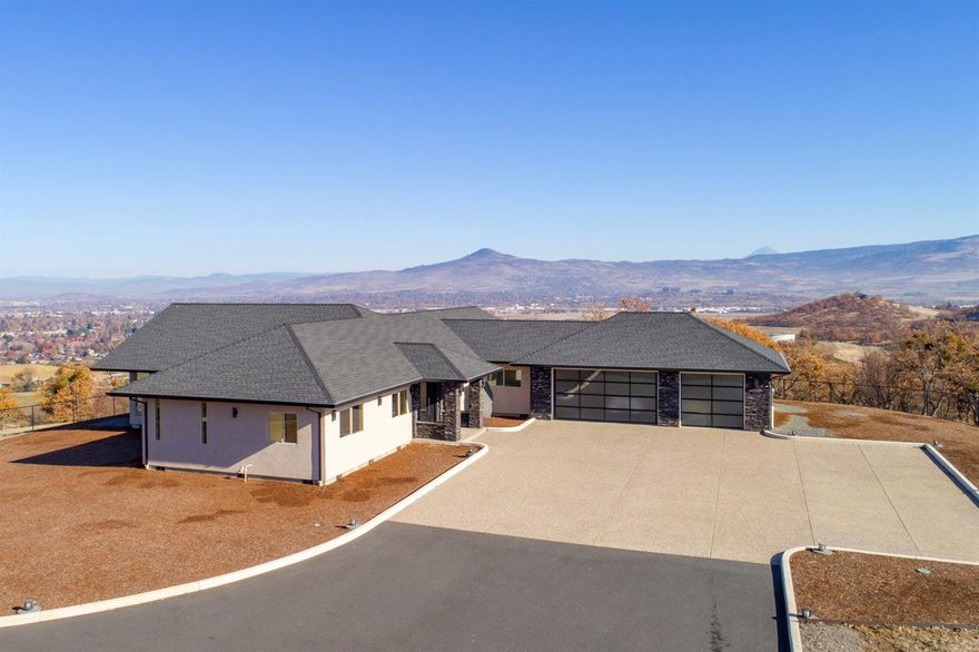Spectacular home with top-of-the-hill 360-degree unobstructed views. Situated on 3.94 acres only 10 minutes from Medford and Jacksonville. Distinctive home with state-of-the-art amenities: Heated tile floors, Geothermal heat pump, sensor lighting, Lutron electronic controls of cameras, security system, heating, lighting, shades. Great Room has vaulted ceiling, walls of windows, built-in entertainment center, wet bar, unique fireplace. Kitchen has stone counters from Africa, island with raised custom eating bar, stainless appliances. Incredible master suite with vaulted ceiling, wall of windows, freestanding tub filled by ceiling fixture. Bath with heated floor, back-lit counters, beautiful custom glass sinks, unique tile and glass shower. Two custom closets w/pullout racks. Guest suite with walk-in closet and ensuite bath. Office, guest bath and utility area. Lovely patio w/ awning perfect for enjoying city lights and mountain views. Spacious 3-car garage w/lots of storage.