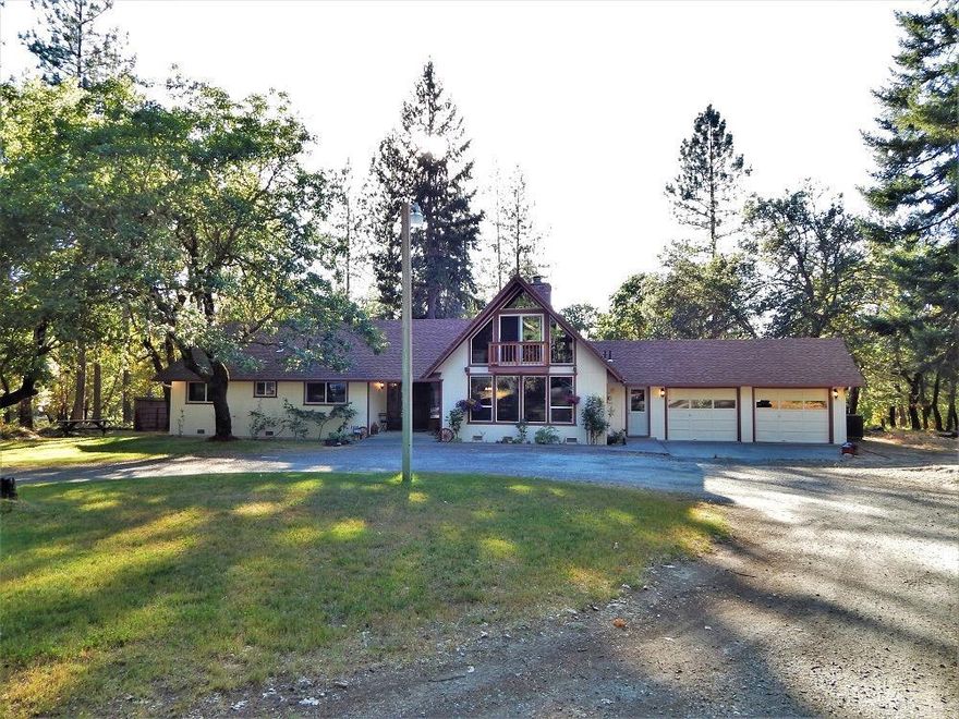 Quiet & serene family home - peaceful 5.06 acres. Lg shade trees keep house cool. Home welcomes you in with its large picture windows & vaulted living room ceiling & inviting fireplace. This home boasts 3 baths, 3 lg beds, loft, exterior balcony, & 2482 Sqft! Solid oak floors, updated kitchen w/ beautiful Hickory cabinets & granite tile counter tops, newly remodeled bathroom, remodeled master suite w/ walk-in shower, hickory cabinets, granite countertops, & matching vanity. Tons of storage in the multiple closets & walk-in attic space! Oversized laundry room w/ slate floors & utility sink. All new vinyl windows. New deck & concrete patio out back perfect for enjoying sunsets. Dog run & separate dog yard. Attached 2-car garage, finished w/ room for storage. 20' x 31' Metal Shop w/ concrete floor & 220 power. All power lines are underground. Property is set 1/4 mile off main road w/ a shared driveway. 10 minutes to hospital. Well flow test from 2 yrs ago = 8.4 GPM. Appointment only.