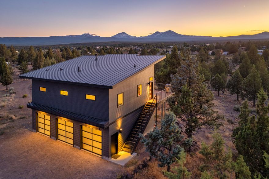 Stunning Midcentury Modern Home with Year-Round Mountain Views. Enjoy breathtaking mountain views every day from this beautifully updated midcentury modern home, situated on 15 fully fenced private acres.This 2-bedroom, 2-bathroom residence offers a seamless blend of modern upgrades and timeless design. Inside, you'll find newly installed hardwood floors throughout, fully remodeled bathrooms, and fresh exterior paint. The open living space flows effortlessly to a large deck perfect for entertaining, relaxing, or watching the sunset from your hot tub.
A fully finished 120 sq. ft. outbuilding with a mini-split system provides flexible space for a home office, guest suite, yoga studio, or creative retreat. Put the oversized 3 car garage to use with all your central oregon toys. The property is zoned for livestock, bring your horses, cows and more. A rare opportunity to own usable acreage with privacy, stunning views, and versatile living options,  including power hook-ups for an RV.