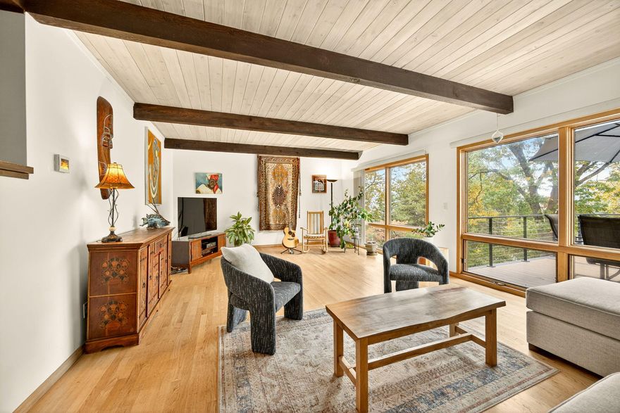 Spacious and full of character, this home offers beautiful views and comfortable main-level living. The 4 bed, 4 bath design blends late mid-century architecture with modern updates. The kitchen features maple cabinets, granite counters, stainless appliances, and a built-in dining nook. Wood floors, open beams, and large windows create warmth and natural light throughout. Bathrooms are tastefully updated with tile, newer vanities, and stone counters. The upper level includes the en suite primary bedroom plus one additional bedroom and bath, while the lower level offers two bedrooms, a common space with a gas fireplace, and two bonus rooms for a home gym or storage. Enjoy outdoor living on the expansive composite deck overlooking the hills, or explore nearby walking trails. With a metal roof, large lot, and flexible layout, this home is ideal for multigenerational living or a potential ADU (buyer to verify). A perfect blend of comfort, charm, and opportunity.