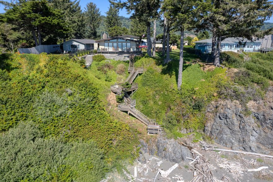 Incredible home on 0.96 acres of Oceanfront Land! This property has an amazing deck that leads to a putting green and stairs right to the beach. This home is newly remodeled with a primary suite on the main level. 32x32 RV Garage + third stall for boat, 1/4 bath/exercise room off the garage. Greenhouse, two tax lots. The main parcel is 0.7 acres plus the vegetation line parcel is 0.26 acres. Gated, fenced and private!