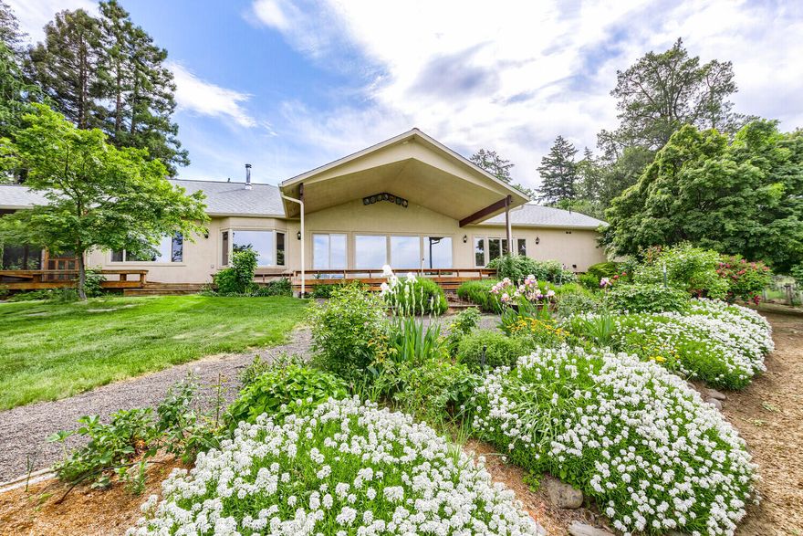 Sited on a beautiful rural Talent EFU lot of 5+ tranquil acres w/panoramic views, yet just 2 miles to downtown Talent & 7 miles to downtown Ashland, this custom, single-level home has been beautifully updated. The 2,905SF main home has 3 bedrooms, bonus room, sunroom, office & 2 full baths + a 4th bedroom/guest room w/add'l bath & private entry. The large galley kitchen has ample seating, 2 pantries, wine fridge, commercial fridge/freezer & induction range. The open dining & great room areas feature vineyard & mountain views & wood stove + screened-in porch overlooking the koi pond. Laundry area w/storage + 2 car attached garage w/ ½ bath & storage. An add'l  2-car garage, RV garage + add'l parking w/easy in/out access. EFU zoned, solar powered entry gate, propane tank & back-up generator, 5,000 gal holding tank to irrigate gardens, 4 acres of TID rights. An add'l driveway allows access to the barn w/tack room, hay barn & 3 covered stalls + riding arena. See attached amenity list.
