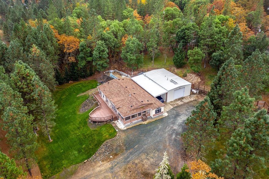 If you're looking for a country setting then look no further. This large home sits on 5.8 acres with creek frontage, fenced and manicured yard with in ground sprinklers, 50x30' steel framed shop that is insulated and heated, and a couple additional outbuildings as well. The house has a great floor plan with large bedrooms and an additional office off the master bedroom as well. Great deck over looks the back yard and has remote awning. Tankless water, fireplace, vaulted ceilings, and much more. Large generator, leased Propane tank, and water holding tank will allow you to live off the grid if you so desire. Paved RV parking with all hook-ups. This property is very well kept and move-in ready for its new owners.