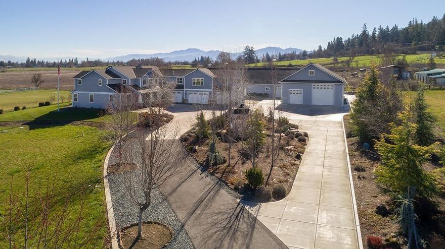 Attention SHOP lovers! This beautiful Estate includes a 6400 sq ft detached air temp control shop w/ 16' doors, full bth & RV pull through garage. The quality constructed 5211 sq ft home sits on approx. 5.93 acres w/additional attached 4 car garage, in-ground sprinkler's & irrigation rights! Greeted by 23' vaulted ceilings & lg windows to take in Valley & Mts. Views. Lg formal dining, glass pocket doors to office w/ built-ins. The Great rm features a River Rock, natural gas, log fireplc. Lg. kitchen incl. subzero ref, dbl ovens, Lg island w/granite counters, built-in microwave & compactor. French doors off of breakfast rm lead out to an in-ground pool. The grand Master Suite, located on the main level, features dbl sinks, lg steam shower w/dbl shower head heads & seating, lg walk-in closet & French doors leading to the patio. The additional 3 bdrms & 2 full bths are located on the 2nd level + a lg rec rm w/dry bar. Paved circular driveway w/gated entry, fenced for animals or vineyard.