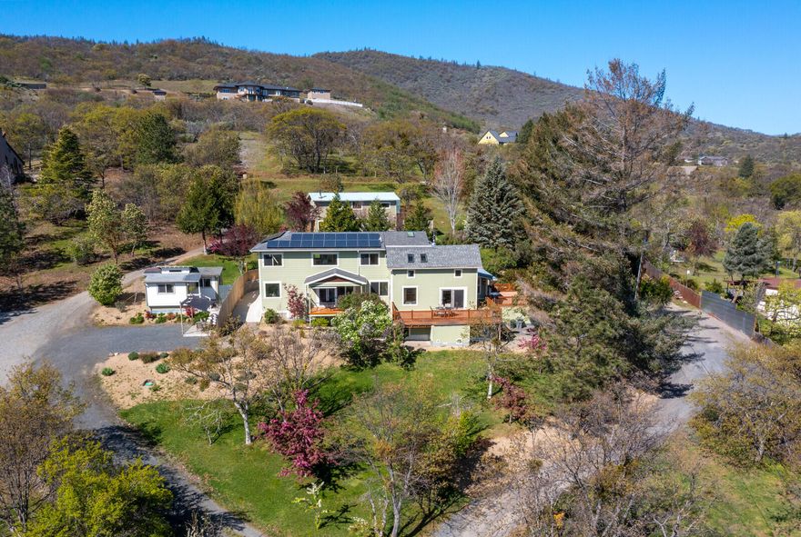 Beautifully renovated farmhouse with incredible mountain views on nearly 3 acres. This stunning home is only minutes from downtown Ashland yet provides the space and privacy of country living. A 2017 addition expanded this already lovely home that now has two primary suites on the main floor. The new primary has a wall of sliding glass doors and a private patio that takes in the views. The living area is open concept with a chef's kitchen, including a Wolf range and custom cherry cabinets. A huge deck with views is ideal for indoor/outdoor living. Upstairs are two more bedrooms and a massive entertainment room with a wet bar and views for miles. There is a detached guest house that is perfect for guests or an in-law set up. Additionally, a large studio/shop/office with a half bath is ideal for a home business or art space. The landscaped grounds are stunning and include a fenced garden area. A large solar array offsets energy costs and adds to the appeal of this amazing property.