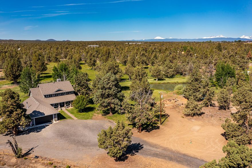 You'll fall in love with this beautiful turn-key ranch in Northeast Bend! Tucked back from the road, and meticulously maintained 10+ Acre property with beautiful parklike setting, 4 Acres of COI irrigation, 2 ponds, irrigation equipment, and 1360 SF barn with tack room. Fenced property offers easy access to 45 square miles of Badlands Recreational Wilderness. Featuring 3,262 square feet of living space, this quality home is sure to please with welcoming living room showcasing soaring floor-to-ceiling stone fireplace, new luxury vinyl plank flooring, and large farm style kitchen with granite countertops and stainless steel appliances. Luxurious main & upper level primary suites plus additional junior suite upstairs. The large covered front porch is the perfect space to relax and enjoy the serene setting. The 4-car garage with shop area offers plenty of room for all your recreational toys. You'll want to allow plenty of time to explore this special property!