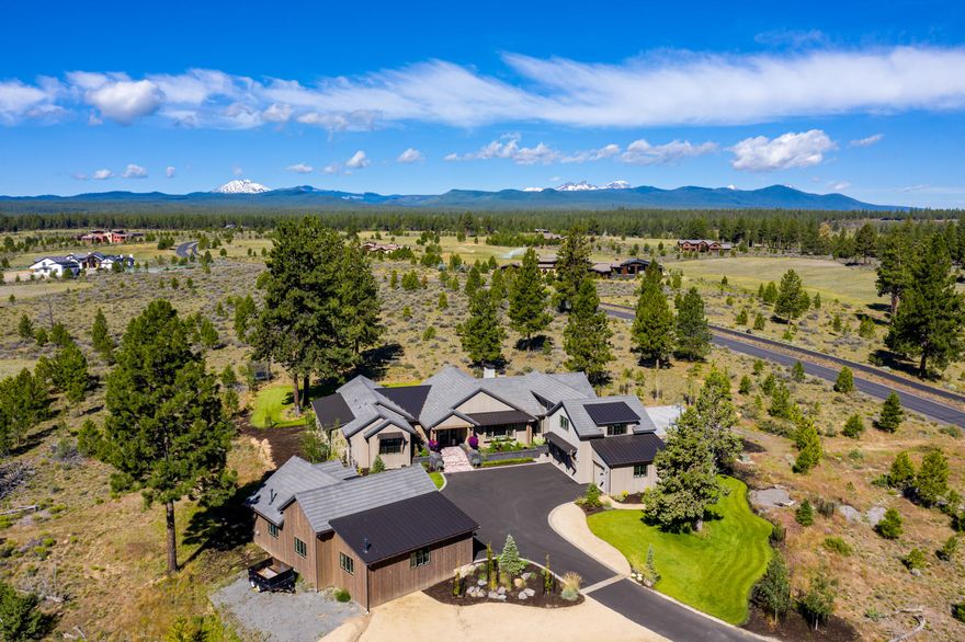 This spectacular modern farmhouse sits perched on an elevated 10-acre lot in the exclusive Highlands at Broken Top neighborhood, offering extensive Cascade mountain views in an unmatched setting. Vaulted 20ft ceilings in the great room create a light-filled retreat from dawn to dusk. Beautiful rough-sawn oak floors and natural wood accents lend to the farmhouse feel, while tall doors & ceilings keep the home open and airy. Chefs will love the gourmet kitchen w/ Thermador & Wolf appliances, Pental Quartz counters, & walk-in pantry. The well-appointed owner's suite features sliding doors to the patio and a spa-like bath w/ radiant floors & transitionless tile shower. All 5 beds are suites in this Arrowood home, providing comfort for family & guests alike. Upstairs, a bonus room could be a gym or home office. Outside, find a 19ft Swim Spa, sport court, & large patio w/ fireplace & wiring for heaters. This home also boasts several smart features.