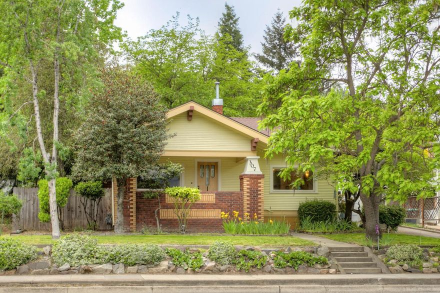 Lovely Vintage Craftsman. Located just 5 easy blocks to the Ashland Plaza and Lithia Park, this precious home offers a spacious covered front porch entry that welcomes you into a delightful living space. The living and dining area include many light capturing windows, beautiful wide moldings, brick wood burning fireplace, solid wood flooring, antique light fixtures and a wall of built-ins that encase a lovely stained glass window and built-in hutch. Cheerful kitchen with black and white tile flooring, a cozy breakfast nook surrounded by windows and easy access to patio. Bathroom and bedrooms all have solid wood flooring. Large and private mature backyard with gorgeous willow tree, greenhouse and planter boxes. Great basement with lots of storage.
