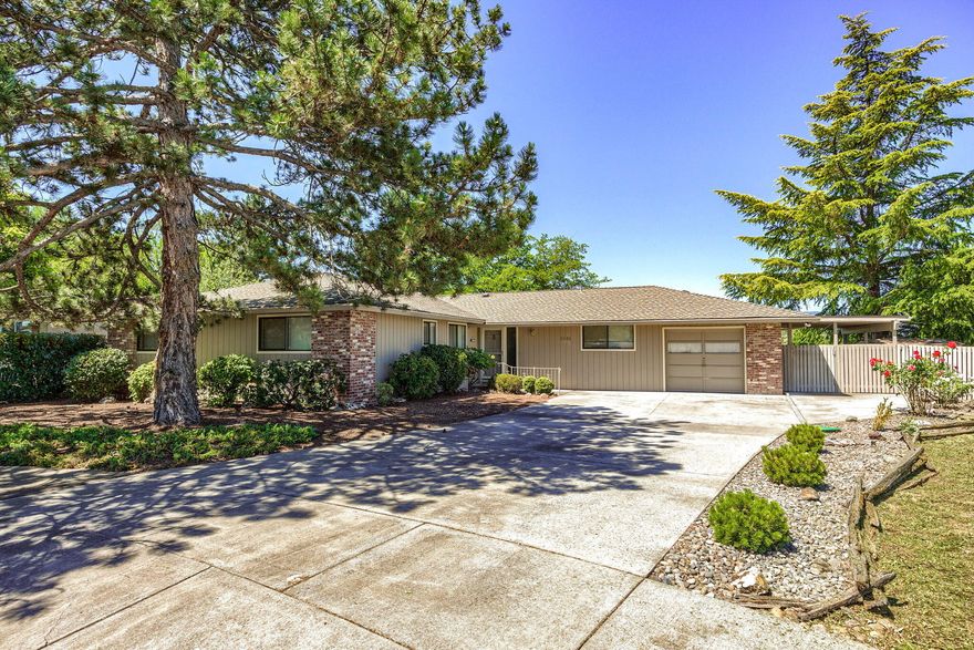 Discover comfort in this 4-bed, 2-bath haven spanning 1,960 sq ft on .28 acres. Embrace one-level living in this thoughtfully designed home featuring two inviting living spaces, one boasting a charming sunken living room and the other enhanced by a cozy gas fireplace. Entertain in the open-concept layout, seamlessly blending living, dining area, and kitchen with bar top seating. There is a one-car garage with a humble shop area or utilize the small RV/boat parking for added convenience. Centrally located, this gem offers easy access to amenities. Step outside to a nicely hardscaped backyard, complete with a lovely patio and compact water feature, perfect for relaxation and outdoor gatherings. Experience the warmth and convenience of this delightful home.