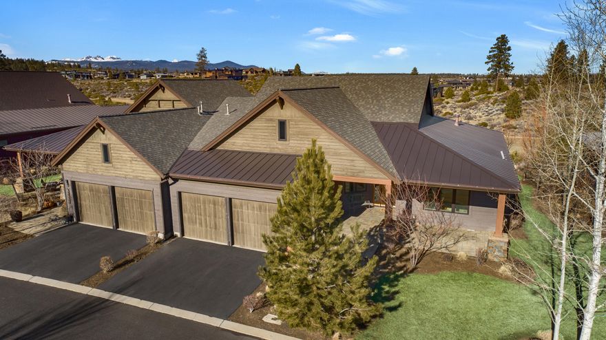 Stunning single level end-unit townhome perched on a natural ridge, offering Cascade Mountains to the west, overlooking Tetherow naturally landscaped hillsides and golf course. Designed for seamless living, the open floor plan boasts high ceilings and expansive windows filled with natural light, bringing the surrounding beauty right into the living space. The primary suite, perfectly positioned to take in the views, features an ensuite bath with a tiled walk-in shower and walk-in closet. Two additional rooms offer privacy and versatility: one serves as a den or office space, while the other is an ensuite bedroom, providing a sense of separation from the main living areas. The gourmet kitchen is designed for both hospitality and utility featuring a second prep island and sink integrated into the Jenn-Air appliance suite for added functionality and a kitchen island with counter seating. This spacious townhome offers an elegant, low-maintenance lifestyle in a beautiful natural setting.