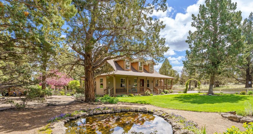 Beautiful home on 5.96 acres with a PARK-LIKE setting and 1.6 acres of COI irrigation rights.  Lush landscaping includes 4 ponds with lily pads and manicured lawns.  Enjoy the wrap-around front porch, back deck and the covered deck overlooking the fish pond.  This updated home has an open great room w/wood burning fireplace and kitchen/dining area with luxury vinyl floors, custom cabinets, stainless steel appliances and Corian counters. Solid wood doors/trim throughout.  PRIMARY bedroom on MAIN LEVEL and updated guest bath with walk-in tile shower. Upstairs BONUS ROOM (12 x 28), accessed through garage, is perfect for office, craft or exercise room.  Large 2-car attached garage, 728 SF SHOP with drive-through garage doors and 30 x 16 covered RV STORAGE. Large garden shed and green house/chicken coop. Fenced and cross fenced.  Shared well.  Roof replaced 2015, HVAC replaced 2022, new exterior paint in 2024.  HORSES allowed.  NO HOA or CCRs.  Room for ADU, zoned MUA10.