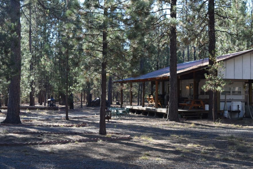 Come build your dream home, or stay in a 1995 single wide park model mobile home with 2 tipouts, 1 bed (possible second sleeping area)1 bath home that stays with the property. Home and deck are fully covered to protect from the elements.  Home is connected to well and septic.  3 Rv hookups, storage shed, fully fenced and gated. Corner lot with a second deck and gazebo, great layout. Close to La Pine state park, 15mins to Deschutes river. All personal property is optional.