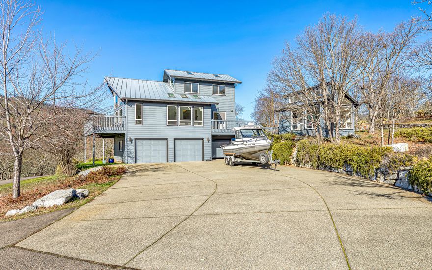 Beautiful country estate sits on 5 acres & additional adjoining 5 acre parcel, to total approx 10 acres with majestic mountain views galore. This home was built in 1996 & features 18+ foot vaulted ceilings, new heat pump, large windows, great natural lighting, mudroom, central vacuum, hardwood floors and metal roof. Great room offers views of Woodrat Mountain that hosts world class launch sites for hang & paragliding. Spacious kitchen has abundant cabinetry, tile counter tops, propane gas range, and eating bar. Huge primary bedroom with fantastic views, two skylights, walk-in closet, attached bathroom has tile floors & large shower. Large laundry room with counterspace, sink & cabinets. Huge 3-car garage offers a deluxe workshop plus a finished office/den with laminate floors. Outbuilding w/sink, garden beds with fencing, chicken coop, useable land, and open space. Paved driveway entrance with security gate. Just minutes to wineries, shopping & restaurants in the town of Jacksonville.