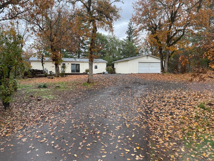 1.17-Acres with 2-bedroom, 2-bath home within Shady Cove city limits? Yes, that's right! Over 1-acre in town with a home and oversized garage/shop. City sewer, Hiland Water + it has an active well. Gated property leads freshly rocked driveway, new carpet, new stove and lots more to offer. Tucked away in the trees. Open floor plan, parquet in kitchen, nook, pantry, light, bright, clean and ready for a new homeowner.